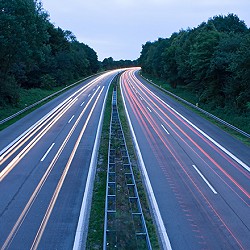 Empty roadway between two tree filled areas